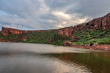 Sabahları dağlarla çevrili antik tapınakla çevrili göl, Badami Karnataka Hindistan 'ında Agastya Tirtha kıyılarındaki Bhutanatha Tapınağı' nın güzelliğini gösteriyor..