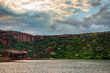 Dağ arkaplanı ve parlak gökyüzü ile el değmemiş göl sabah görüntüsünde Agastya Tirtha 'nın Badami Karnataka Hindistan' daki güzelliğini gösteriyor..