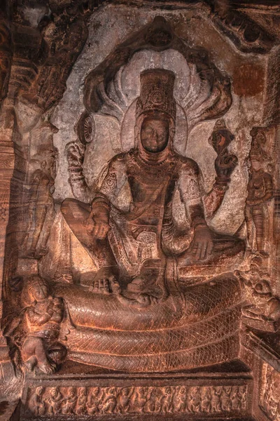 Badami Vishnu 'nun Adi-Shesh' in üzerinde oturan mağara tapınağının duvarında.