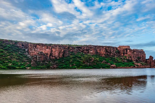 Dağ zeminine ve parlak gökyüzüne sahip saf göl, Badami Karnataka Hindistan 'ında Agastya Tirtha kıyılarındaki Bhutanatha Tapınağı' nın güzelliğini gösteriyor..