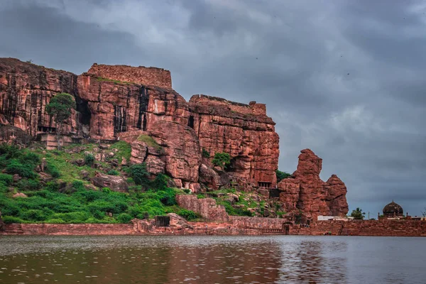Alacakaranlıkta bulutlu gökyüzü olan dağ, Badami Karnataka Hindistan 'ında Agastya Tirtha sahillerindeki Bhutanatha Tapınağı' nın güzelliğini gösteriyor..