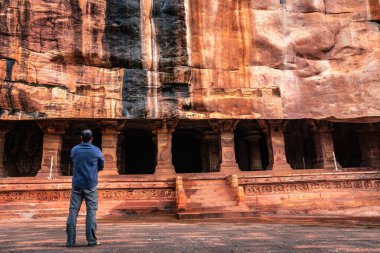 Sabah görüntüsünde antik kaya kesimindeki mağarada duran adam Badami Karnataka Hindistan 'da çekilmiştir. Muhteşem chalukya hanedanlığı sanat eserleri unesco miras alanı ve yeridir..