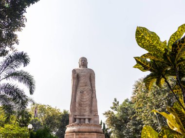 Benzersiz bir bakış açısıyla parlak gökyüzü arka planına sahip antik dev Buda heykeli taş mimarisi