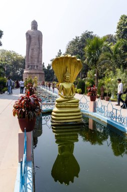 Buddha heykeli, Wat Thai Sarnath Tapınağı 'nda, Sarnath uttar pradesh Hindistan' da, 18 Şubat 2025 'te, gün boyunca açık havada selam veren insanların olduğu bir heykel çekilmiştir..