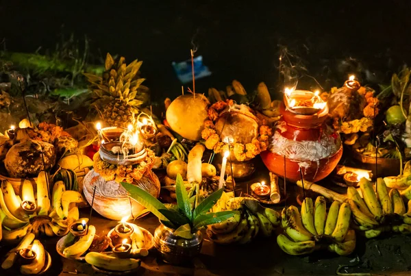 Kutsal chhas puja ritüeli. Meyveli ve nehir kenarında parlayan diya ile daali.