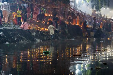 Chhas puja ritüelini daali adaklarıyla ve nehir kıyısında parlayan bir lambayla kutlayan kişi, 2008 Kasım 'ında Janakpuri Yeni Delhi' de çekilmiştir..