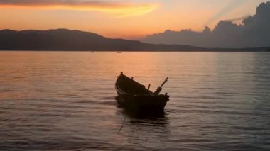 Durgun durgun suların üzerinde alacakaranlık ve renkli akşam bulutları.