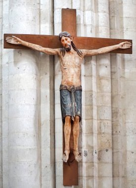 İsa Mesih bir binanın beyaz taş duvar üzerinde ahşap bir haç anıt üzerinde.