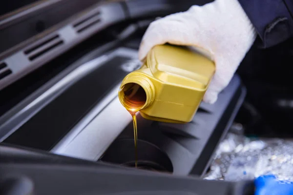 Derramando óleo do motor em um motor de carro — Fotografia de Stock