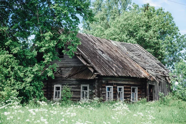 Oude afbrokkelende verlaten huis tussen de bomen — Stockfoto