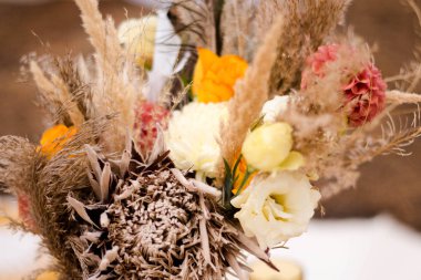 Doğal tonları ve kurutulmuş çiçekler çiçek Sonbahar buketi. turuncu dahlias, sarı güller, protea, spikelets