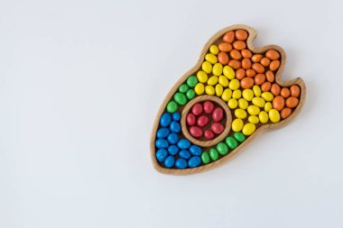 beyaz bir arka plan üzerinde bir roket şeklinde kırmızı, sarı, yeşil, mavi, turuncu farklı renklerde şeker dragees. konsept bayrak gökkuşağı lgbtq topluluğunun gökkuşağı bayrağının renkleri gurur