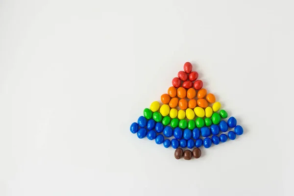 Christmas tree made of multi-colored sweets on a white background. The colors of the rainbow flag of the LGBTQ — Stock Photo, Image