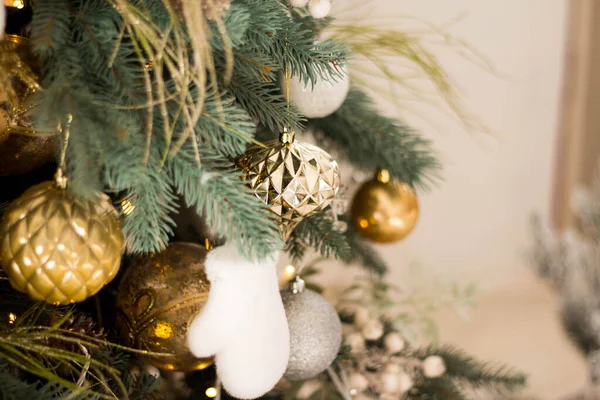 Mooie kerstboom met feestelijk goud, wit decor tegen wazig licht op de achtergrond, close-up — Stockfoto