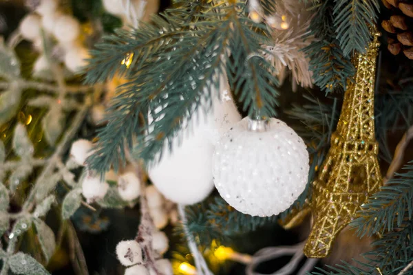 Vacker julgran med festligt guld, vit inredning mot suddiga ljus på bakgrunden, närbild — Stockfoto