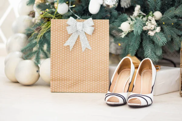 Stijlvolle kerstcadeau dozen op houten vloer onder kerstboom. Cadeaus en ornamenten in en papieren zakken. Vakantie winkelen. Geschenkverpakkingen — Stockfoto