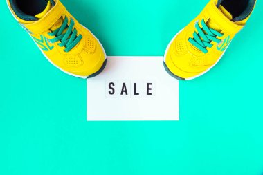 Mavi arka planda bir çift sarı ayakkabı. Kara Cuma