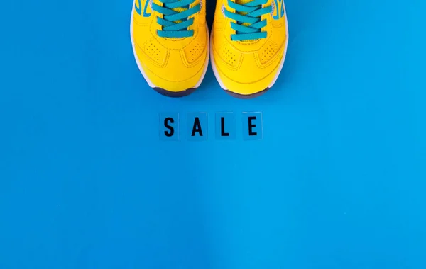 Pár žlutých bot na modrém pozadí. černý pátek — Stock fotografie