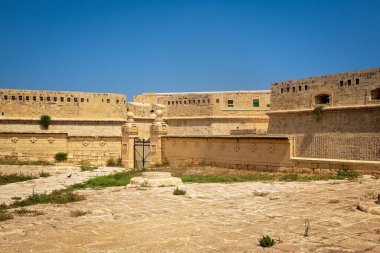 Demir giriş kapısı, ortaçağ duvarları ve eski askeri savunma yapısının korunmuş unsurları olan eski kireçtaşı kalesi..