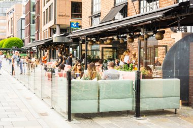 Oslo, Norveç - 22 Haziran 2025: Müşteriler ve garsonlar Norveç 'in Oslo kentindeki Harbour Promenade kentindeki açık hava restoranında yiyip içiyorlar