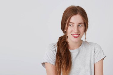 Gülümseyen ve mutlu hissediyorum beyaz duvardan izole yan isteyen tshirt çilli neşeli Kızıl saçlı Genç kadın portresi