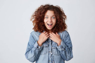 Güzel kızıl saçlı açılan ağız beyaz arka plan üzerinde giyen denim ceket duygu hayret ve mutlu izole olan kıvırcık kadın portresi şaşırttı