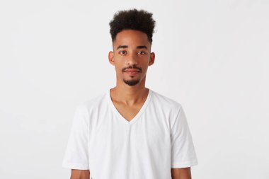 Closeup of confident attractive african american young man with afro hairstyle wears t shirt looks serious and successful isolated over white background clipart