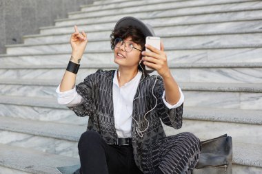 Şuraya bak! Genç çekici iyi görünümlü bayan arkadaş ve showplace bir parmak ile işaret vide yapar. Merdivenlerde sittin mutlu casualy dresed kadın portresi