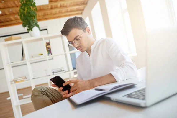 잠겨있는 심각한 사업가 셔츠와 노트북을 사무실에서 테이블에 전화를 — 스톡 사진