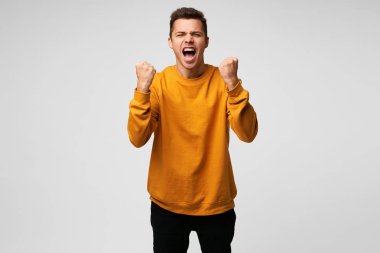 Mutluluktan, beyaz arka plan üzerinde çığlık iyi Ödülü, başarılı anlaşma, olumlu haber, bir yumruk kadar ödüllendirilir, zafer, jesti veren genç mutlu adam gerçekten etkileyici başarılar kazandı