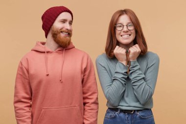 Kızıl Sakal erkek, yakışıklı kapalı atış görünüyor onun kız arkadaşı ve gülümsüyor. Neşeli zencefil erkek, gülümsüyor geniş, mutlu hissediyor, onun gözleri kapalı ve elleri çene yakınındaki tutar ve kazanmak hakkında rüyalar