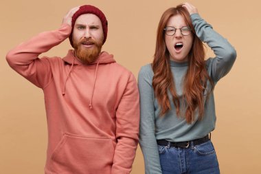 Aman Tanrım! Yatay genç erkek ve kadın ateş, şok, yüz ifadesi, tutun ellerini kafasına hayret. İzole