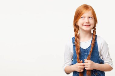 Sol üst köşesinde, düşünceli arıyorum genç bir hayalperest bir beyaz izole bir boş kopya alanı yanında duran bir lezzetli pasta hayal. Kırmızı saç iki bezleri ile kız güzel çocuk