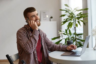 Mutlu genç çekici zencefil sakallı adam çalışan bir laptop WH