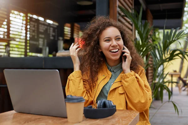 stock image Photo of young dark skinned curly woman siting on a cafe terrace