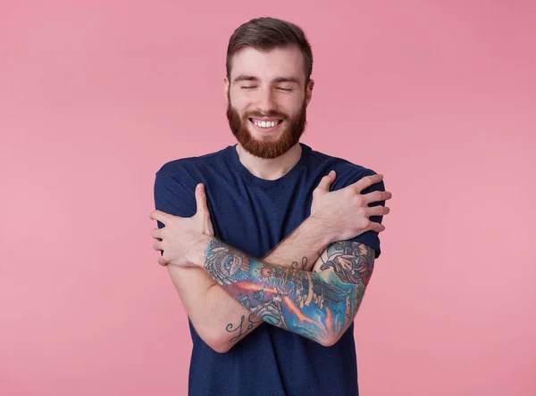 Young happy attractive red-bearded guy with closed eyes, wearing