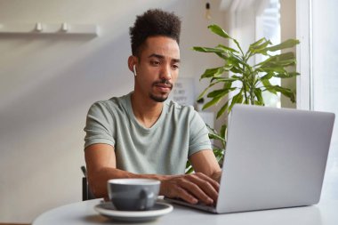 Genç çekici Afrika Amerikan dalgın çocuk, bir masada oturur i