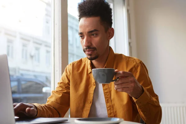 Portrait of young attractive African American boy, works at a la