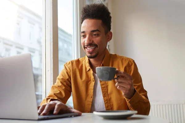 Foto de chico afro-americano atrayente, sentado en un café, c —  Fotos de Stock