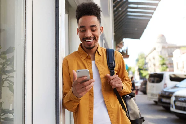 Jeune homme afro-américain joyeux en chemise jaune, veuve qui marche — Photo