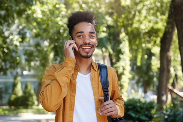 Portrait de jeune homme à la peau foncée positive en chemise jaune, wal — Photo