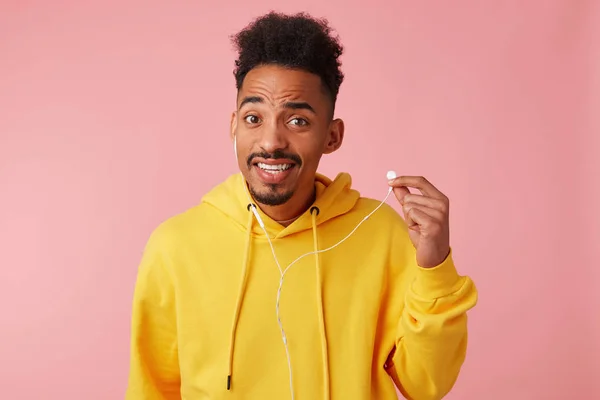 Young wondered african american guy in yellow hoodie, didn't hea — Stock Photo, Image