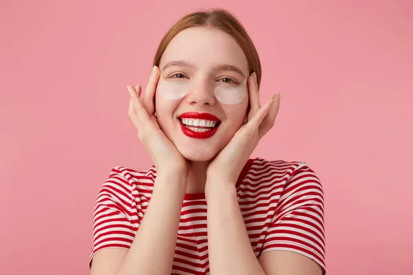 Bonita jovem de cabelos vermelhos senhora em uma camiseta listrada vermelha, com li vermelho — Fotografia de Stock