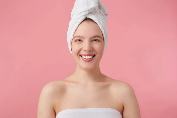 Nahaufnahme einer positiven jungen Frau nach der Dusche mit einem Handtuch auf dem Kopf — Stockfoto