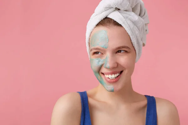 Giovane bella donna con mezza maschera, con un asciugamano sulla testa a — Foto Stock