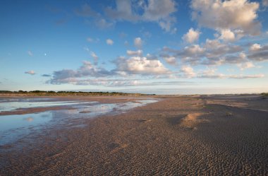 Kum tepeleri ve su birikintileri bulut yansımaları ile