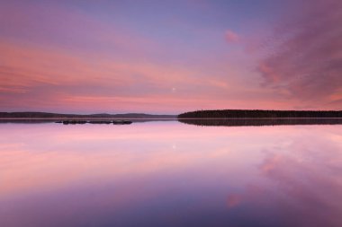 İsveç 'in ortasında sakin bir gölün üzerinde güzel bir gün batımı.
