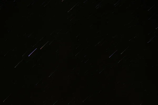 Lines of stars in a dark nighttime sky as the earth rotates