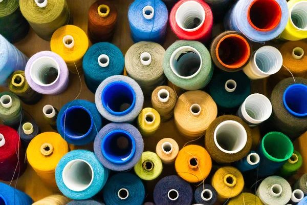 Colorful board coils with a number of multi- colored rolls, sale of sewing materials on market. A set of threads on the coils with thread.