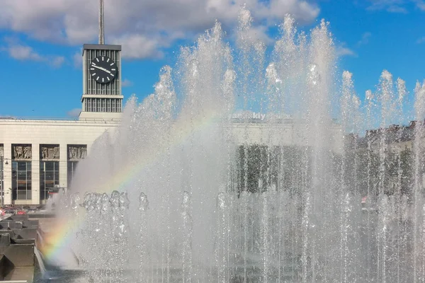 City fountain, water jets with a rainbow on a sunny day.